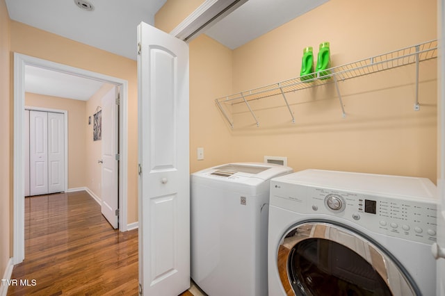 laundry area with dark hardwood / wood-style floors and washer and clothes dryer