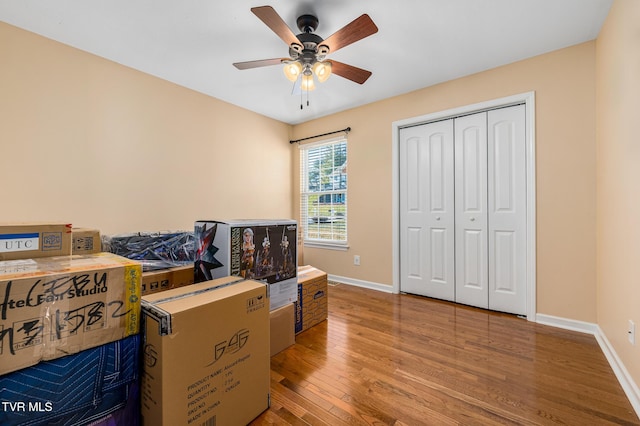 interior space with wood-type flooring, ceiling fan, and a closet