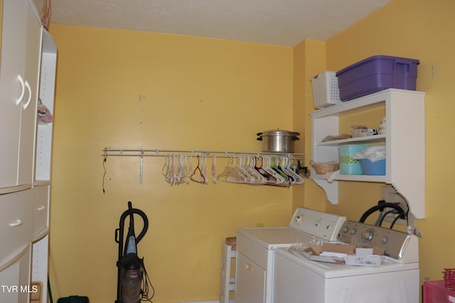 laundry area with separate washer and dryer and a textured ceiling