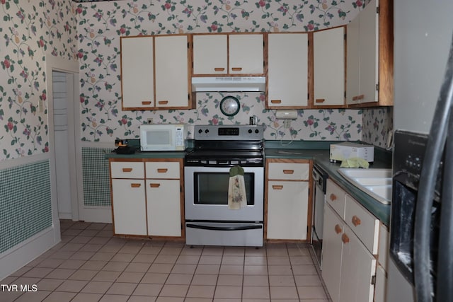 kitchen featuring light tile patterned floors, sink, white cabinets, and appliances with stainless steel finishes