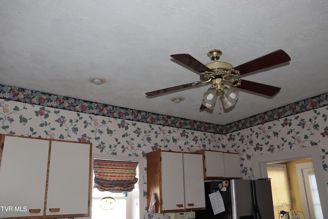 interior details with stainless steel fridge with ice dispenser, a textured ceiling, and ceiling fan