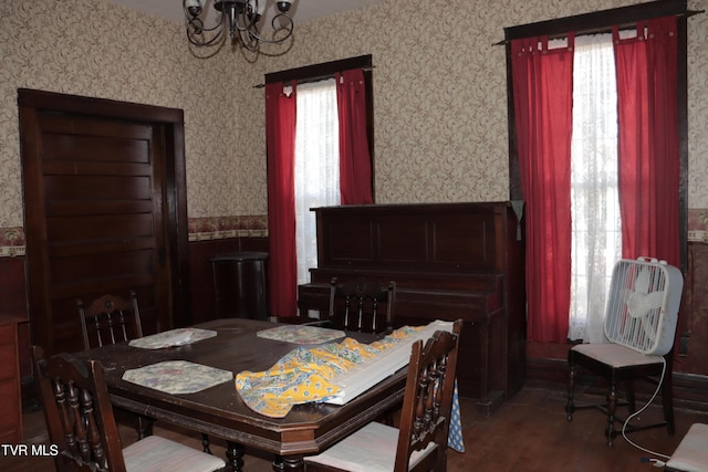 dining room with dark wood-type flooring and a chandelier