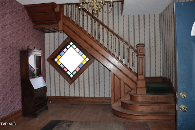 stairs featuring hardwood / wood-style flooring and an inviting chandelier