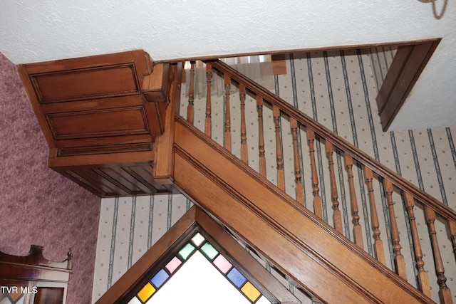 stairs featuring a textured ceiling