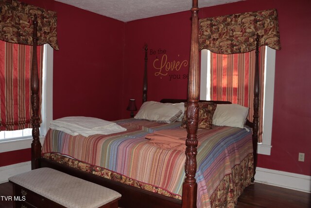 bedroom with dark hardwood / wood-style flooring and a textured ceiling