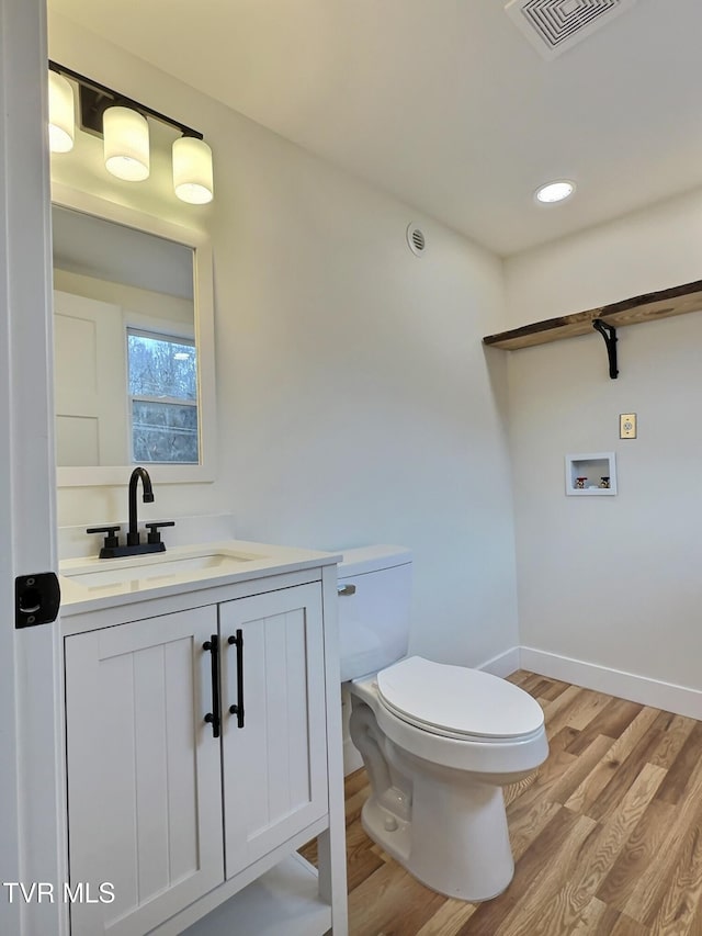 bathroom featuring vanity, hardwood / wood-style floors, and toilet