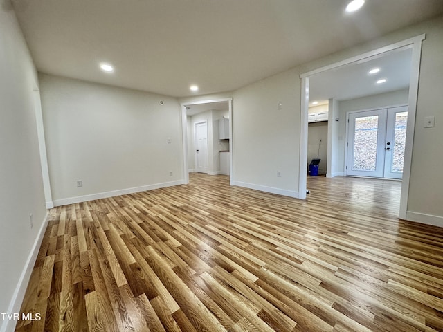 unfurnished living room with light hardwood / wood-style flooring and french doors