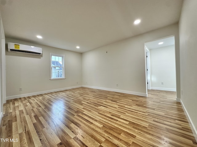 empty room featuring light hardwood / wood-style flooring and an AC wall unit