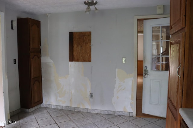 tiled spare room with a textured ceiling