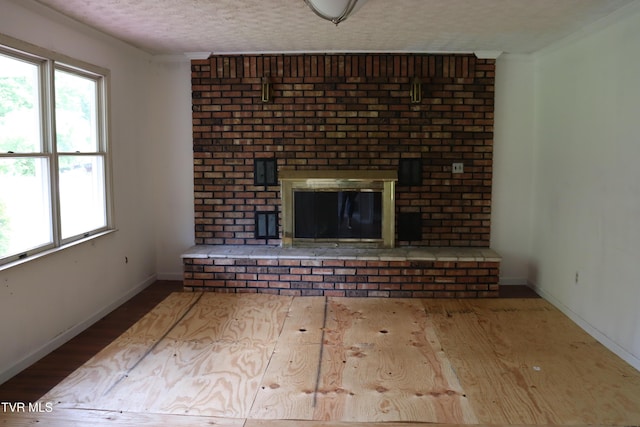 unfurnished living room featuring hardwood / wood-style flooring, a fireplace, and a textured ceiling