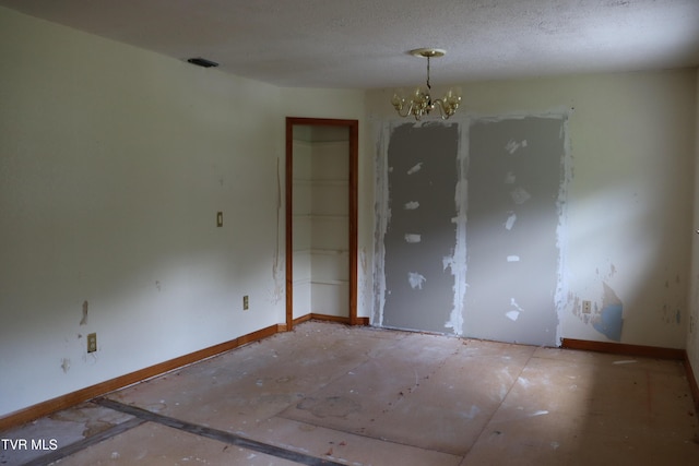 unfurnished room with a notable chandelier