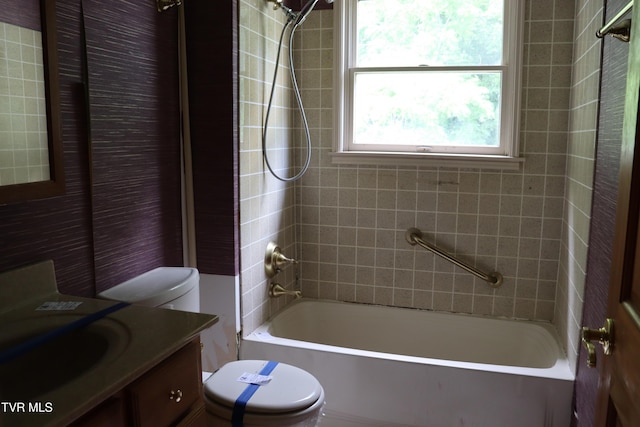 full bathroom with vanity, tiled shower / bath combo, and toilet