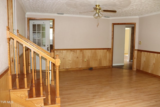 interior space with crown molding, a textured ceiling, and light hardwood / wood-style floors