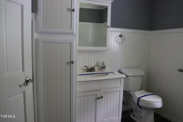 bathroom featuring vanity, tile patterned floors, and toilet