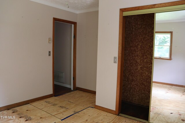 empty room featuring ornamental molding and light hardwood / wood-style floors