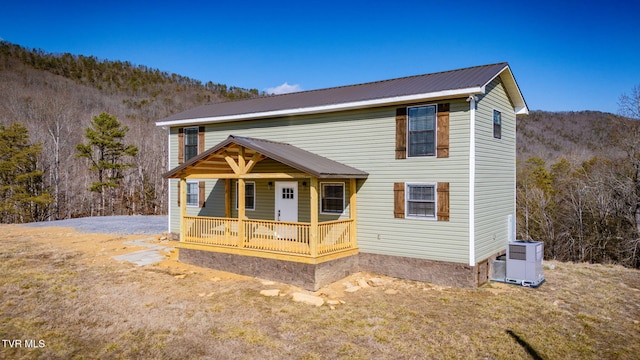 view of front of home featuring a porch, a mountain view, and central air condition unit