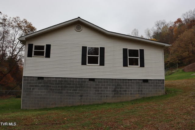 view of side of home with a yard