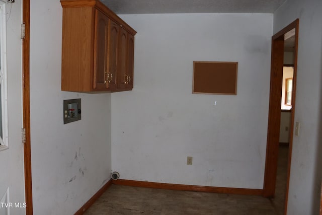 washroom featuring hookup for a washing machine and cabinets