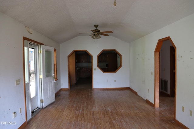 interior space with vaulted ceiling, hardwood / wood-style floors, ceiling fan, and a textured ceiling