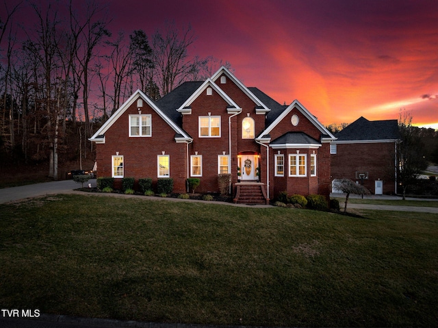 traditional-style house featuring brick siding and a front lawn