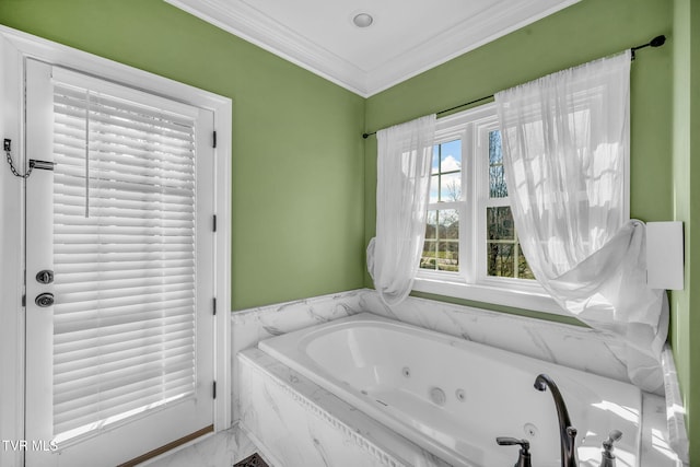 bathroom with ornamental molding and a tub with jets