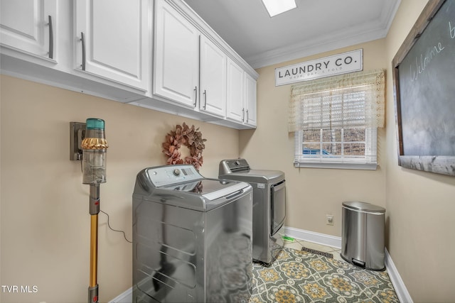 laundry room featuring cabinet space, light tile patterned floors, baseboards, independent washer and dryer, and crown molding