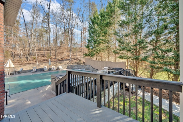 wooden terrace with a fenced in pool and fence