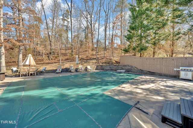 view of pool featuring fence and a patio