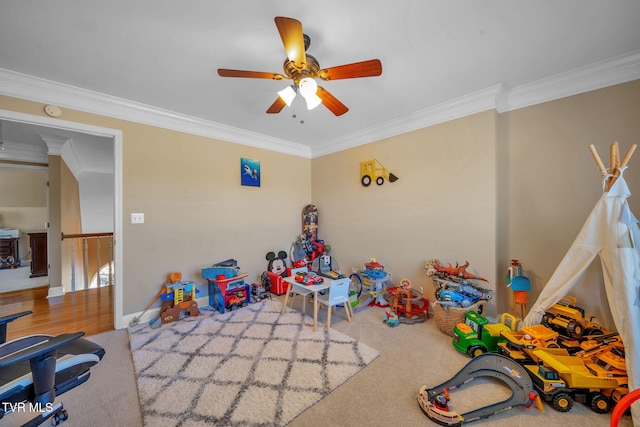 recreation room featuring ornamental molding, carpet, and a ceiling fan