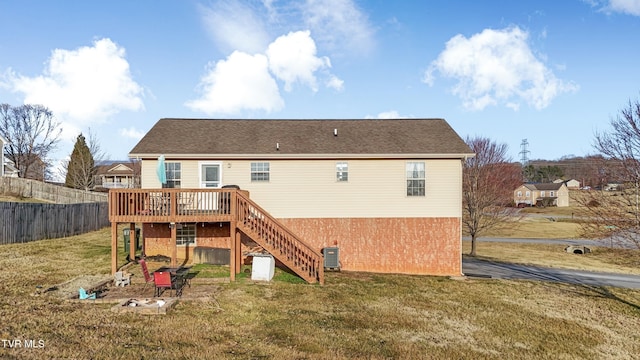 rear view of property featuring a wooden deck, cooling unit, and a lawn