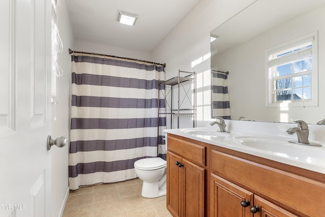 bathroom featuring walk in shower, vanity, toilet, and tile patterned flooring