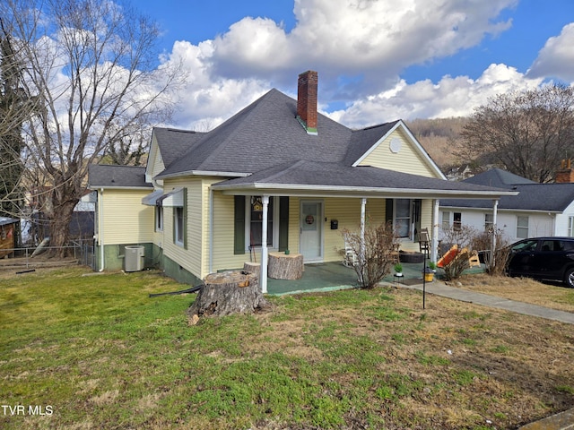 view of front of house with covered porch, a front yard, and central air condition unit