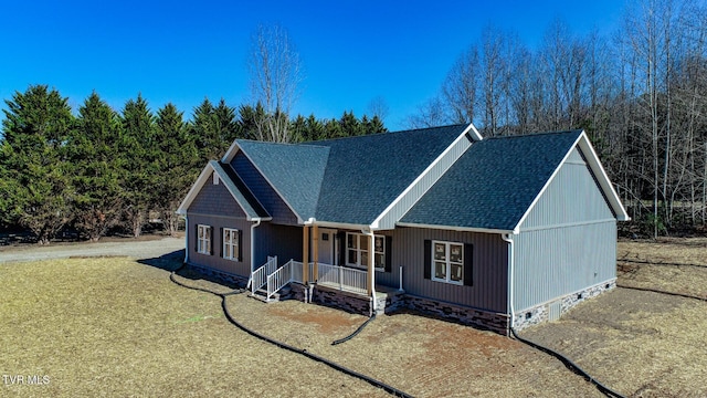 view of front of house featuring a shingled roof, covered porch, and crawl space