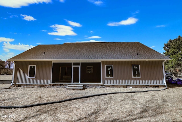 back of property with a shingled roof