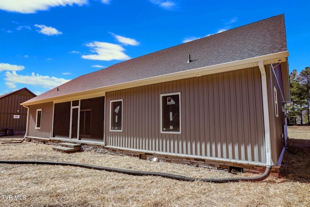 rear view of house with a shingled roof