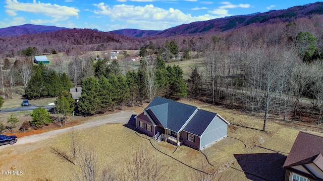 drone / aerial view featuring a mountain view and a view of trees