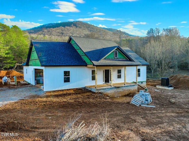 view of front of home featuring a porch, a garage, and a mountain view