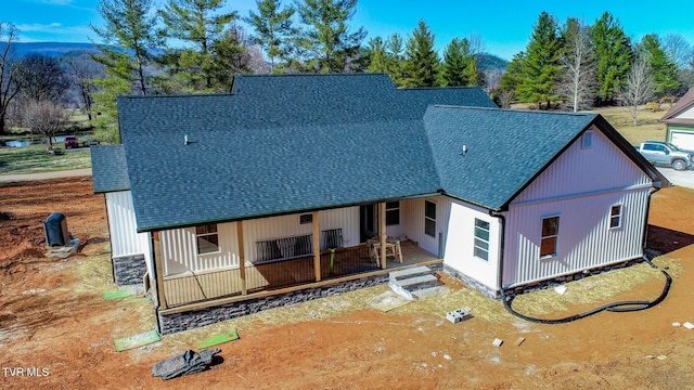 back of house featuring a shingled roof