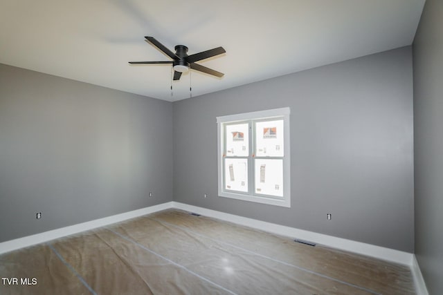 empty room featuring visible vents, baseboards, and a ceiling fan