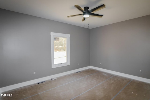 empty room featuring ceiling fan, visible vents, and baseboards