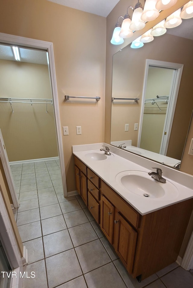 bathroom with tile patterned flooring, vanity, and a notable chandelier