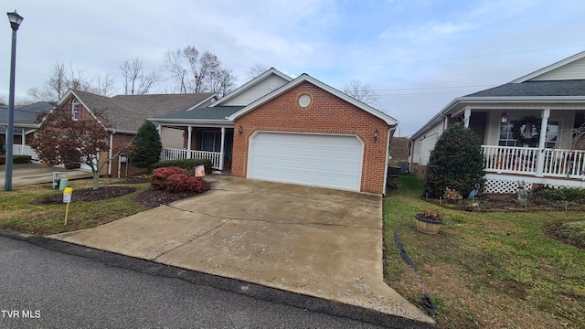 view of front of house featuring a porch, a garage, and a front lawn