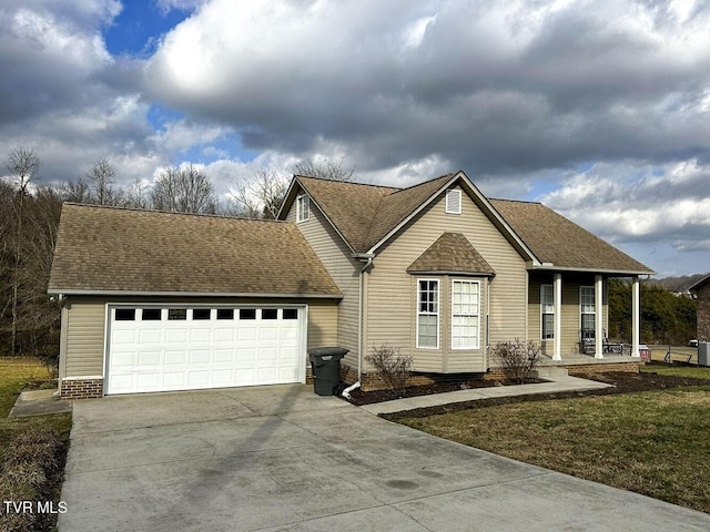 view of front of house with a garage, a front lawn, and covered porch