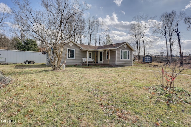 back of property featuring a lawn and a storage shed