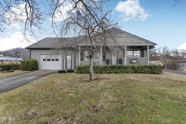 view of front of home with a front yard, an attached garage, and driveway