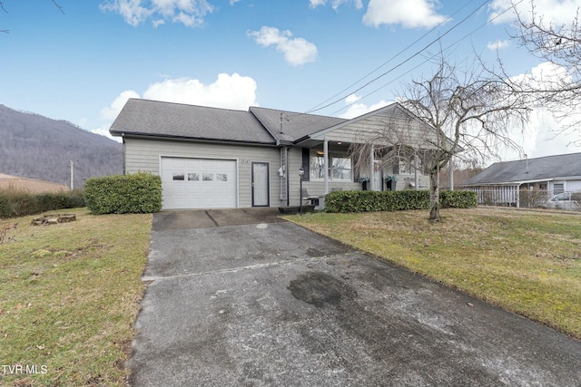 ranch-style house with an attached garage, driveway, and a front yard