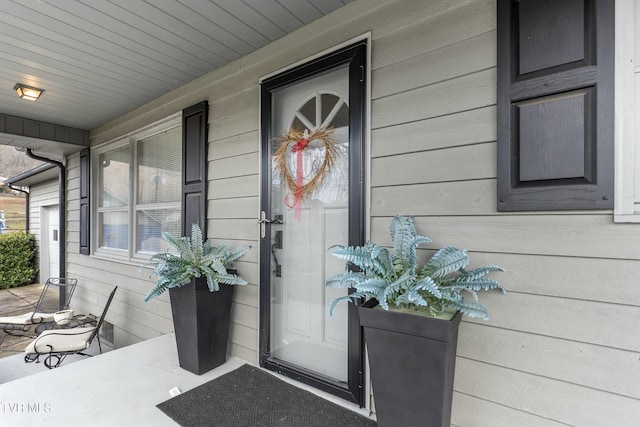 view of exterior entry featuring covered porch