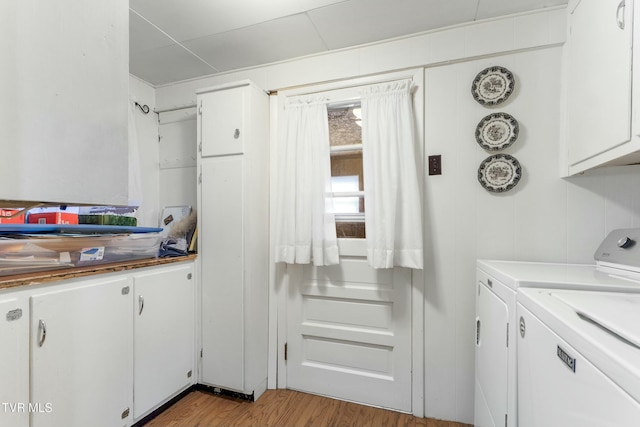 laundry area with cabinet space, wood finished floors, and washing machine and clothes dryer