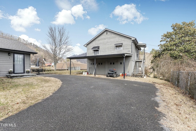 exterior space with stairway, driveway, and fence