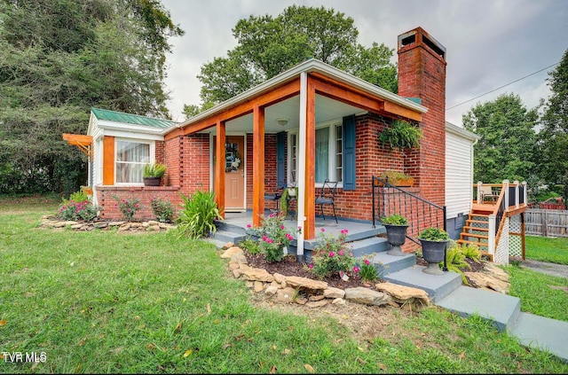 view of front of property with covered porch and a front yard